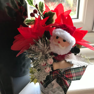 An artificial silk Christmas poinsettia and santa arranged in galvanized pot