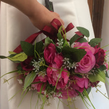 a wedding bouquet of deep pink and burgundy flowers