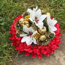 A christmas memorial posy of red roses and carnations