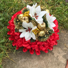 A christmas memorial posy of red roses and carnations