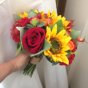a brides wedding bouquet featuring artificial silk roses & sunflowers