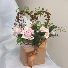 flower arrangement of artificial mocha foam roses in a gift bag