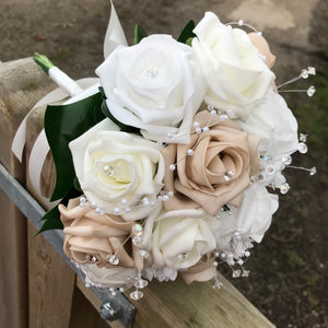 An artificial wedding bouquet featuring beige, white and ivory foam roses