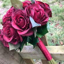 A wedding bouquet of artificial silk burgundy rose flowers