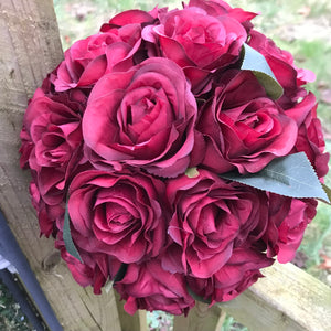 A wedding bouquet of artificial silk burgundy rose flowers