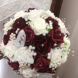 A wedding bouquet of artificial ivory & burgundy rose flowers