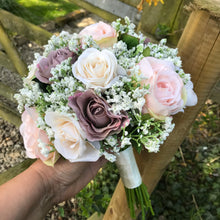 A brides bouquet of gypsophila and artificial silk roses