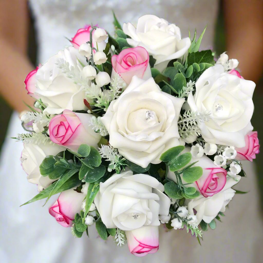 An artificial wedding bouquet featuring pink and white roses