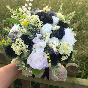 A bridal bouquet of navy blue and ivory flowers