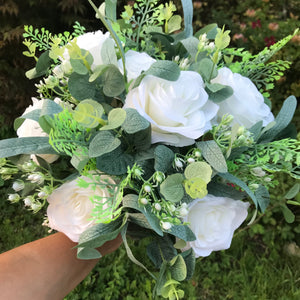 a large wedding bouquet of white roses and peonies