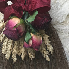 a rustic lucky broom decorated with dried flowers