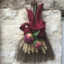 a rustic lucky broom decorated with dried flowers