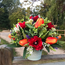 artificial flower arrangement in shades of orange and red