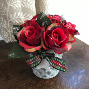 red frosted roses arranged in a metal bucket with tartan ribbon and wooden star