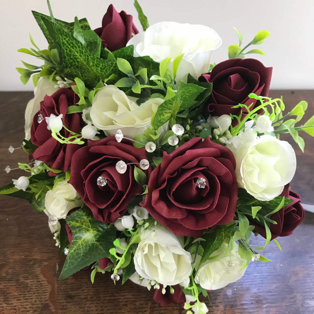 wedding bouquet featuring burgundy and ivory roses