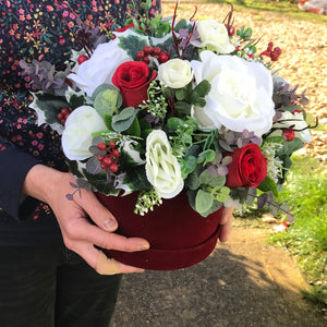A Christmas artificial flower arrangement in luxury velvent hat box