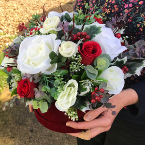 A Christmas artificial flower arrangement in luxury velvet hat box