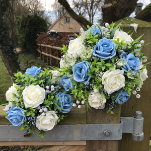 An artificial wedding bouquet of blue and ivory flowers