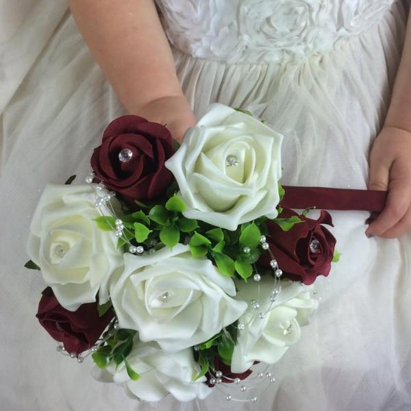 flower girl holding a posy of artificial ivory and burgundy foam roses