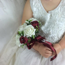 bridesmaid holding a posy of ivory and burgundy roses