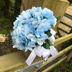 A wedding bouquet collection featuring ivory/white and pale blue flowers