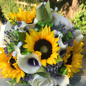 A wedding bouquet featuring calla lilies, roses & sunflowers