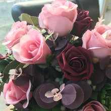 A posy arrangement of dusky pink and burgundy roses