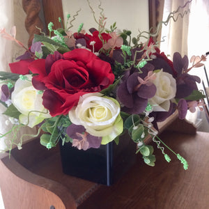 a flower arrangement of red & ivory roses