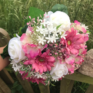 A wedding bouquet of artificial pink and ivory roses & gerbera flowers