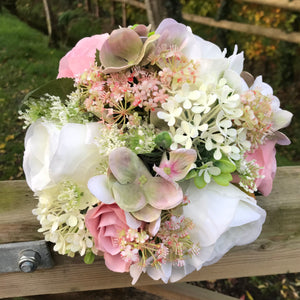 A wedding bouquet of ivory and dusky pink artificial flowers