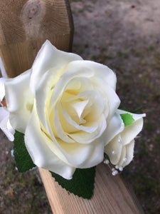 A corsage featuring two open lemon roses