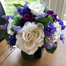 a table arrangement of lilac ivory and purple flowers