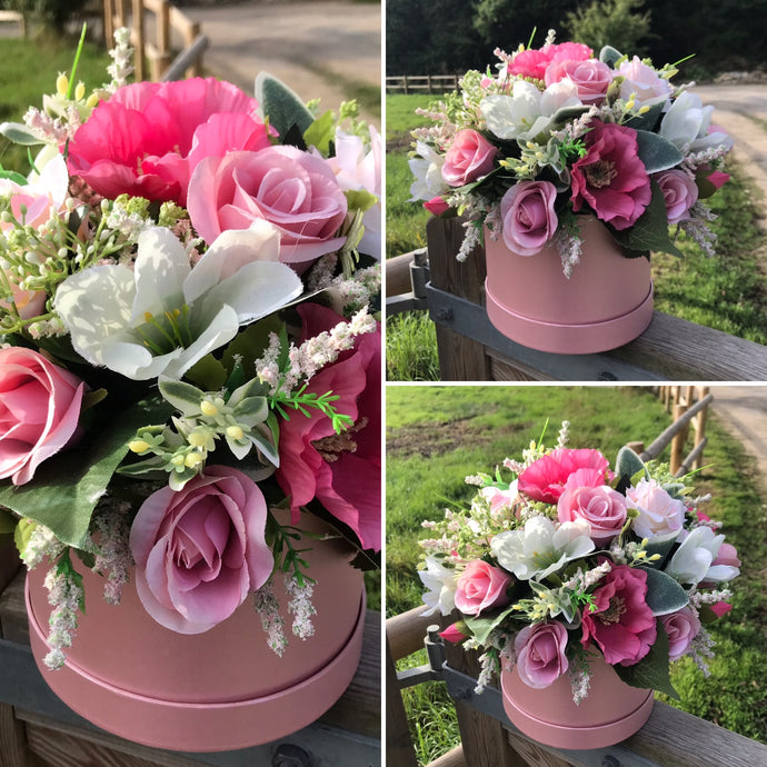 pink aartificial flowers arranged in a pink hat box