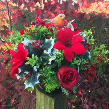 a christmas grave memorial pot with red artificial flower arrangement