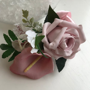 A pink corsage featuring calla lily and roses