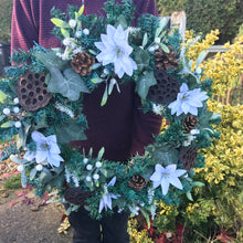 an artificial pine christmas wreath with twigs berries ribbon and cones