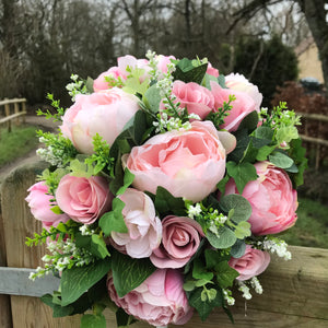 A wedding bouquet featuring pink peonies and foliage