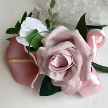 A pink corsage featuring calla lily and roses