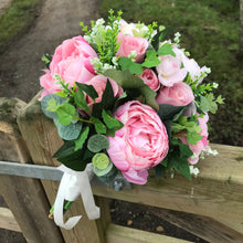 A wedding bouquet featuring pink peonies and foliage