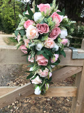 A teardrop bouquet of artificial pink and white roses