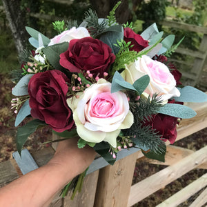 A Christmas bouquet of artificial pink and burgundy roses
