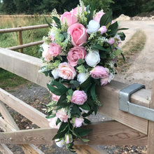 A teardrop bouquet of artificial pink and white roses