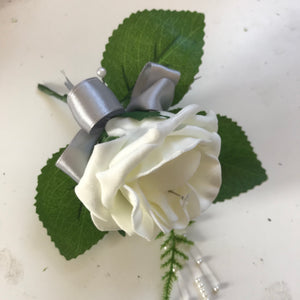 A Foam rose buttonhole featuring pearl strands