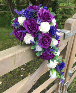 A teardrop bouquet collection of ivory and purple flowers