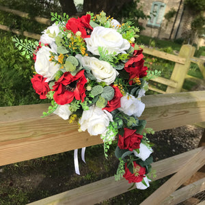 A teardrop bouquet collection of white and red roses and anenomies