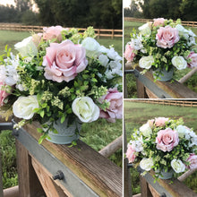 a flower centrepiece of pink and ivory roses and foliage