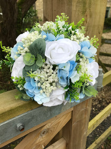 A wedding bouquet collection featuring ivory/white and pale blue flowers