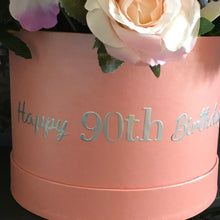 a large artificial flower arrangement in pearlescent hat box