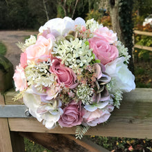 A wedding bouquet of ivory and dusky pink artificial flowers