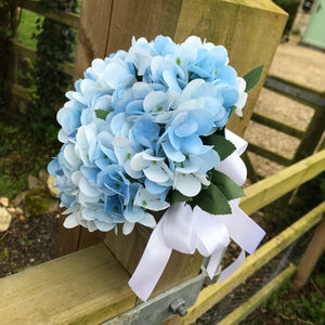 A wedding bouquet collection featuring ivory/white and pale blue flowers